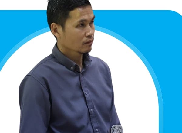 Portrait of Dr Bounxian Phetlamphan, Head of the Department of Forest Resources at Souphanouvong University, speaking with a microphone during a session on climate change and air pollution.