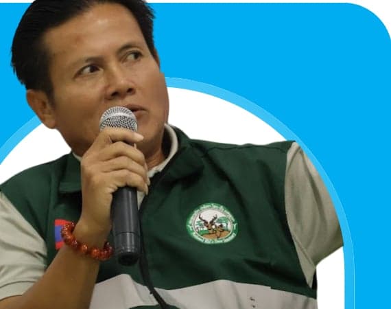 Portrait of Mr Khamphai Saiyalath, Head of the Protection and Conservation Division at the National Eld's Deer Sanctuary, speaking with a microphone during a session on wildlife protection in Savannakhet.